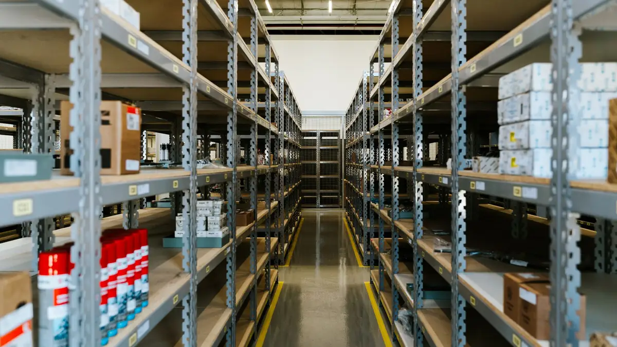 Long aisles of metal shelving holding boxes and stock in an organised warehouse