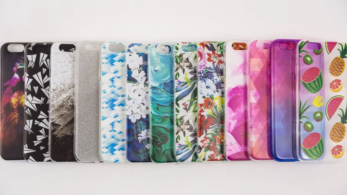 A row of colourful patterned phone cases laid side by side on a white surface